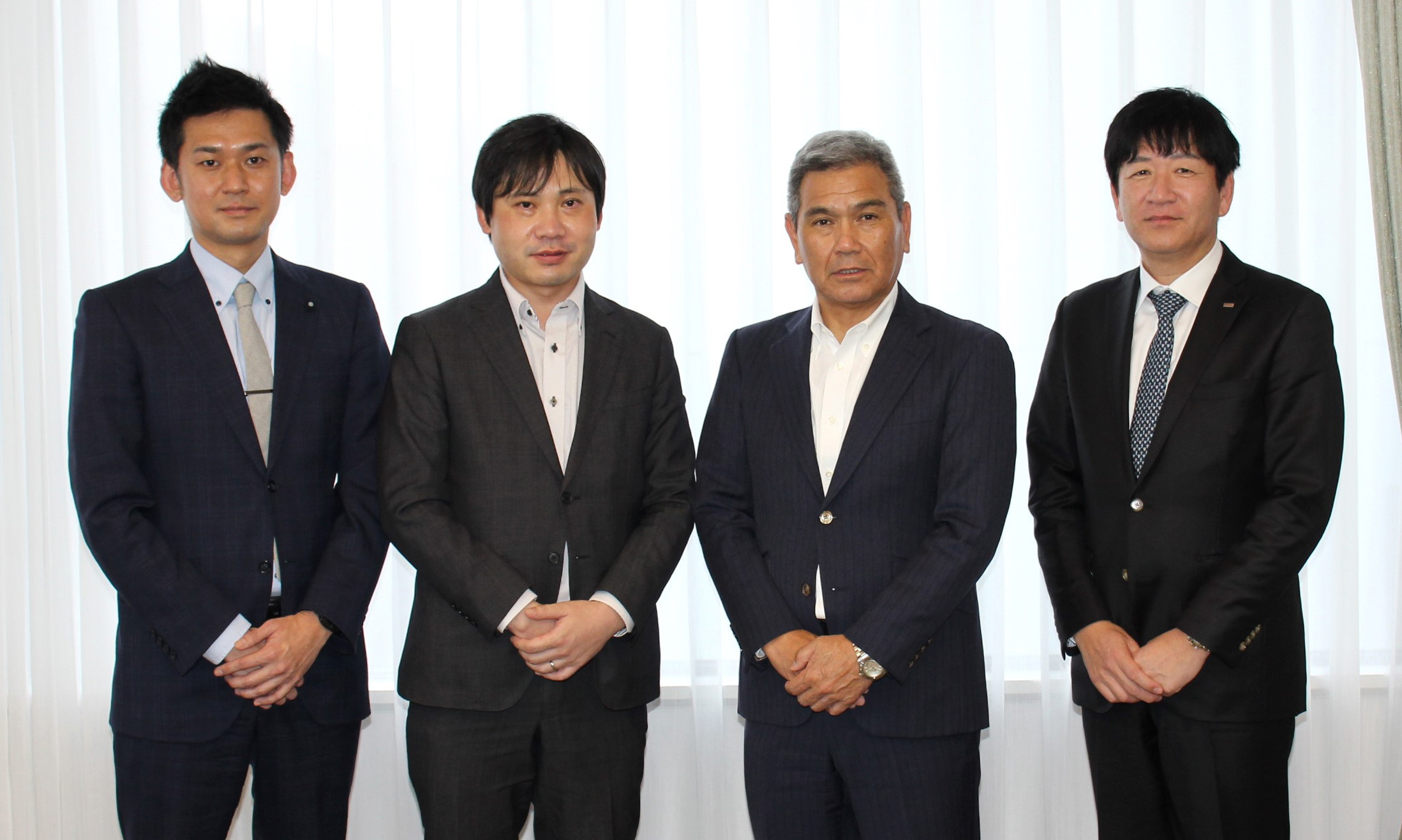 4人が横に並びこちらを見ている写真